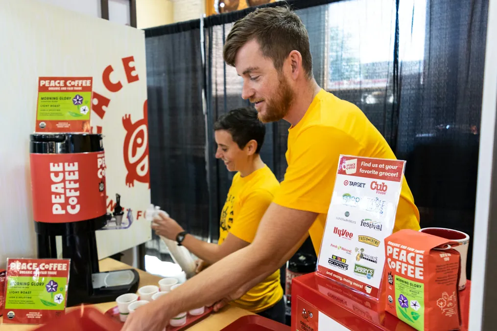 Peace Coffee's Melanie Meegan and Ryan Brown set up the booth for a show